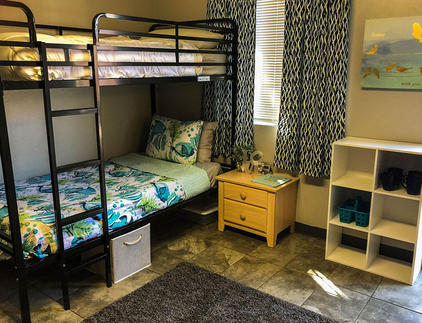 a very neat and clean dormitory style bedroom with a bunk bed.